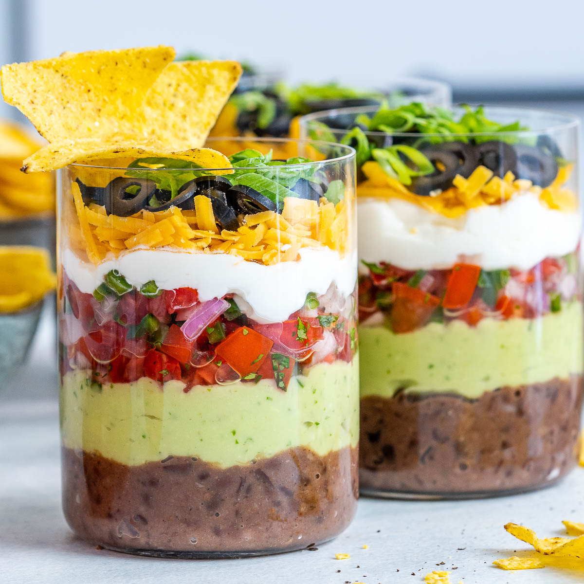 7 layer dip cups with tortilla chips for a backyard party