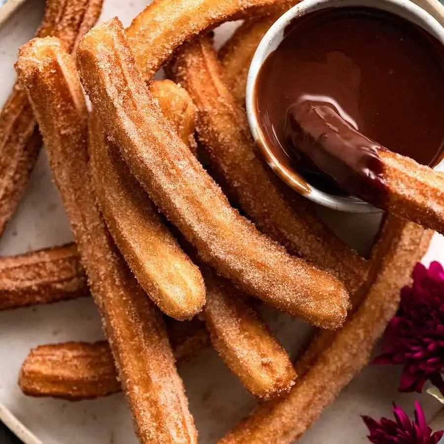 Churros coated in cinnamon sugar with dark chocolate dipping sauce