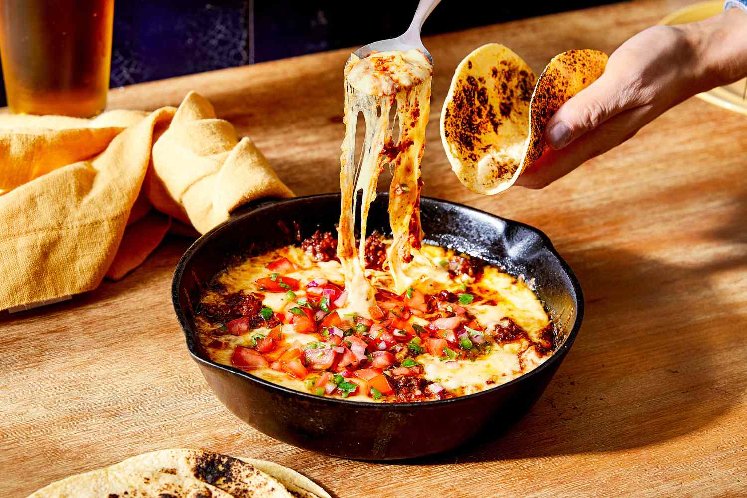 Queso fundido melted cheese with chorizo in a cast iron skillet