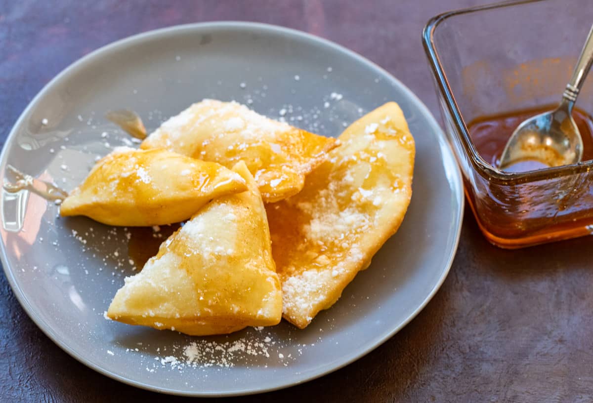 Golden sopapillas puffed and drizzled with honey