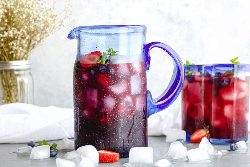 sparkling berry punch in a pitcher with fresh berries and citrus