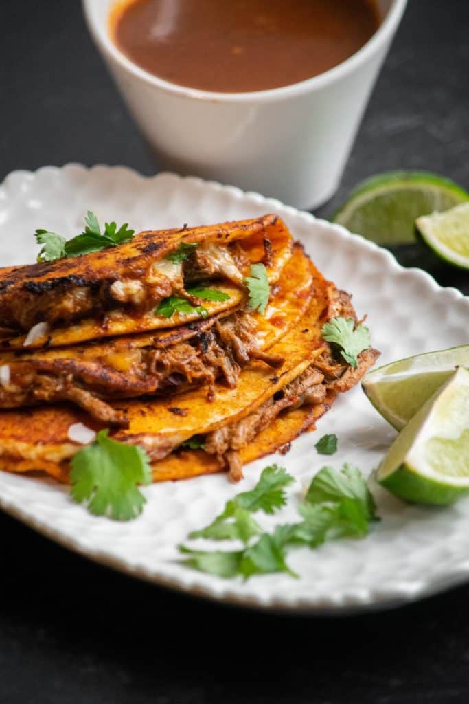 Crockpot birria tacos crispy dipped tortillas with shredded beef and consomme for dipping