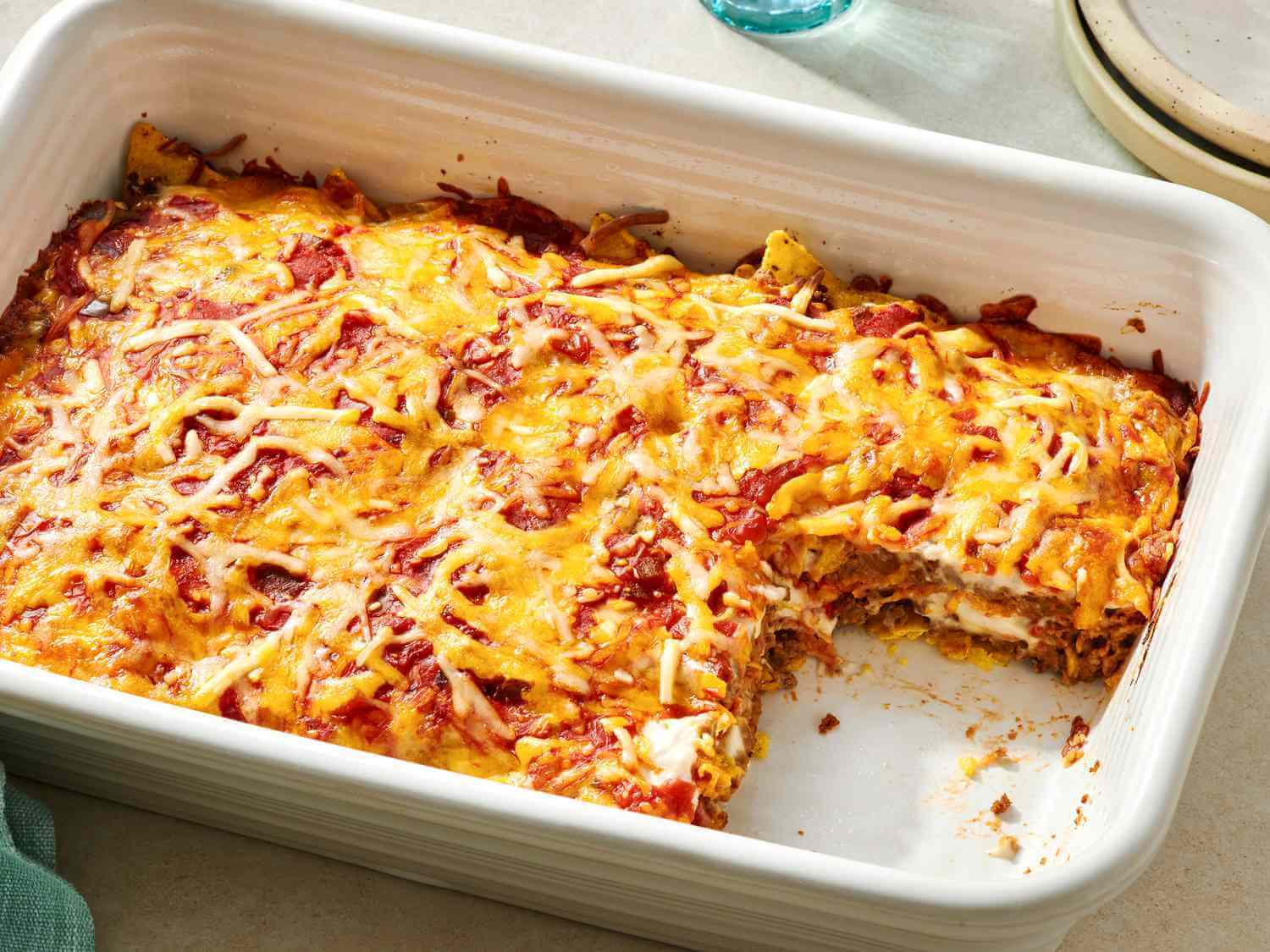 Burrito casserole sliced into squares showing layers of beef beans and cheese