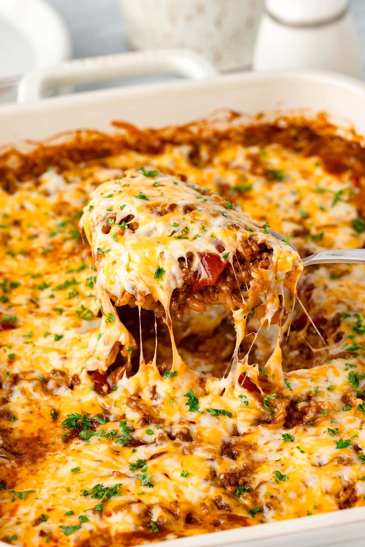 Taco casserole loaded with beef beans cheese and fresh toppings