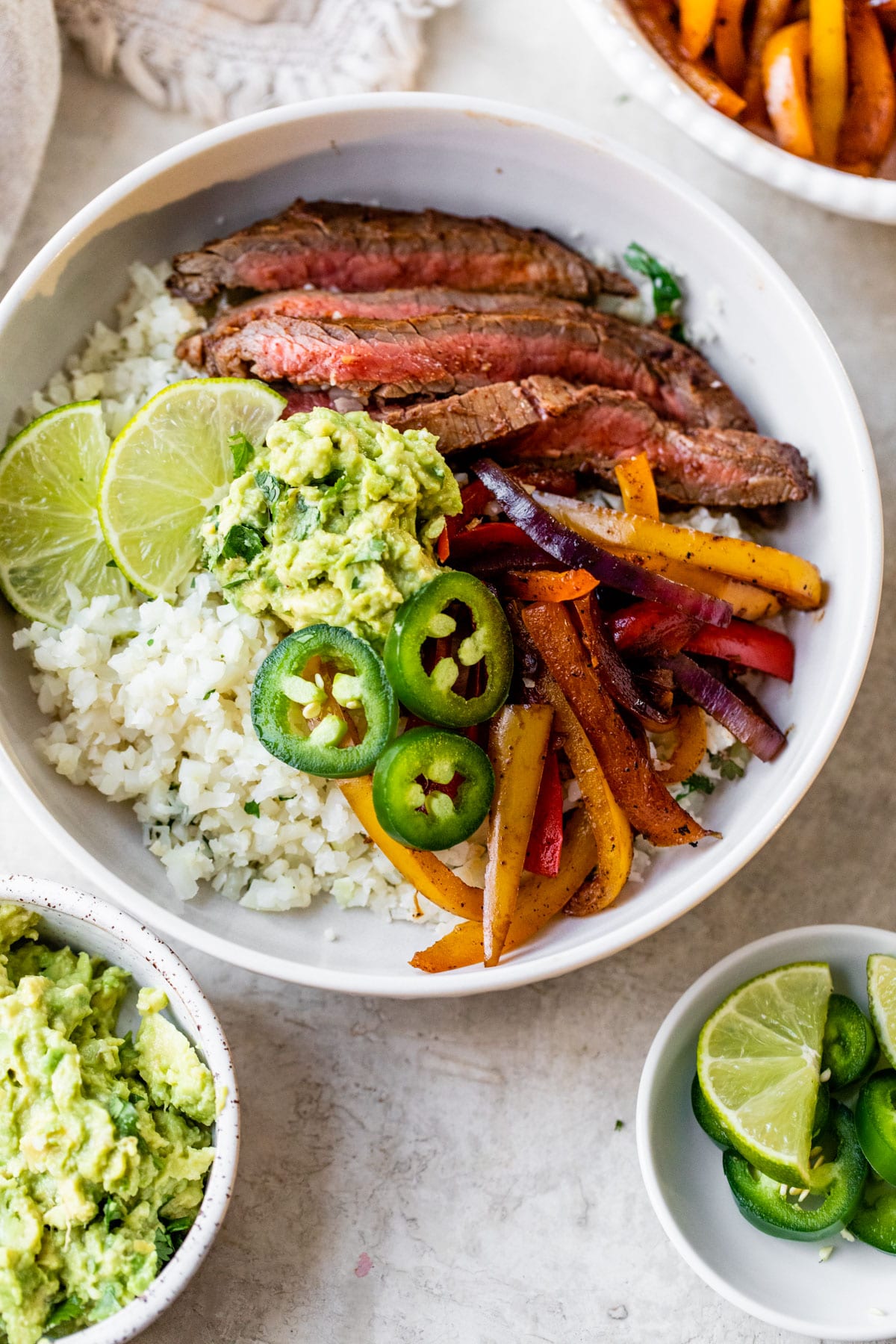 Healthy steak fajita bowls with peppers onions rice and avocado